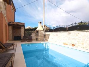 a swimming pool in front of a building with a bridge at House Jasici 2014 in Žminj