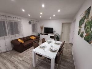 ein Wohnzimmer mit einem Tisch und einem Sofa in der Unterkunft Apartmani Pina 1 in Kaštela