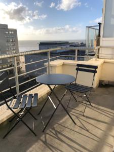 a table and chairs on a balcony with the ocean at Appartement Fr Gilkens Ostende in Ostend