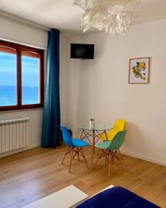 een woonkamer met een glazen tafel en stoelen bij Mondello Beach - Rooms By The Sea in Mondello