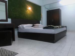 a bedroom with a bed with a green wall at Krissana Mansion in Hat Yai