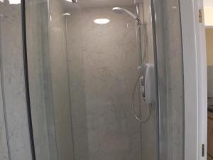 a shower with a glass door in a bathroom at Bonna's Bed And Breakfast in Builth Wells