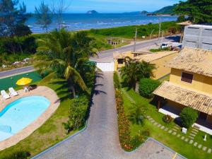 - une vue aérienne sur un complexe avec une piscine et l'océan dans l'établissement Casa 2 Recreio De Buzios 1 - casa em condomínio com vista para o mar, à Búzios