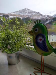 a statue of a bird standing next to a plant at Four Season Apartment Irene in Eisenerz