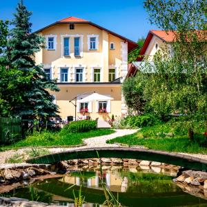 a bridge over a river in front of a building at Boutique Hotel SwissHouse in Mariánské Lázně