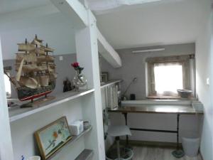 a room with a shelf with a desk and a window at gites Les Lebes - Grange loft in Sempesserre +19 photos