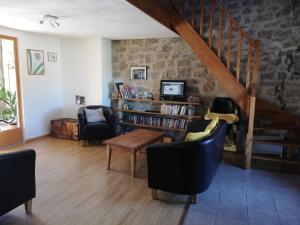 sala de estar con sillas, mesa y escalera en La Maison Bleue23, en Sardent