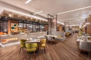 a restaurant with tables and chairs and a bar at Holiday Inn Tianjin Wuqing by IHG in Wuqing