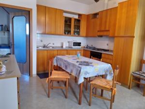 una cocina con mesa y sillas y una cocina con armarios de madera. en Come a casa - near VENEZIA, en Oriago Di Mira