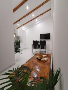 uma sala de estar com uma mesa de madeira e cadeiras em Apartmani Pina 2 em Kaštela