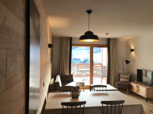 ein Wohnzimmer mit einem Sofa, einem Tisch und Stühlen in der Unterkunft Luxury 2 Bedroom Apartment with view of Mont Blanc in Combloux
