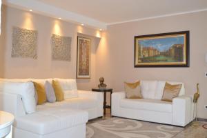 una sala de estar con 2 sofás blancos y una pintura en SAN MARCO3 Apartment, en Venecia