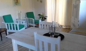 a dining room with white chairs and a table at Marlin Cottage in Chintsa