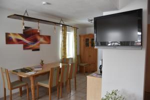 uma sala de jantar com uma mesa e uma televisão na parede em Appartement Sabrina em Haus im Ennstal