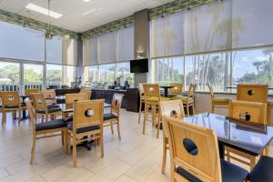 a restaurant with tables and chairs and windows at Quality Inn Bradenton North I-75 in Bradenton