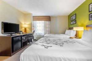 a hotel room with two beds and a flat screen tv at Sleep Inn I-95 North Savannah in Port Wentworth
