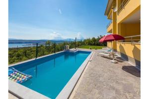 a swimming pool with a red umbrella next to a building at Apartment Heaven Hill in Jadranovo