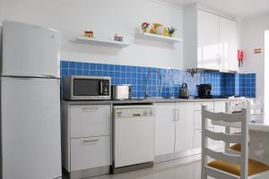 a kitchen with a refrigerator and a microwave at Flipflops Ocean View in Nazaré