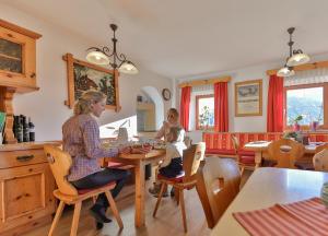 kobieta i dziecko siedzące przy stole w kuchni w obiekcie Jörgishof w mieście Untertscheltsch