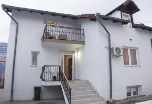 a white house with stairs and a balcony at Adi&Nicol in Sibiu