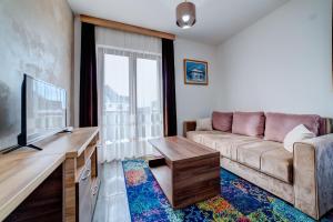 a living room with a couch and a flat screen tv at Zlatibor Hills 31 in Zlatibor