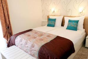 sypialnia z dużym łóżkiem z niebieskimi poduszkami w obiekcie Apartments Grand Pinea w mieście Čilipi