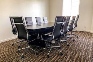 einen Konferenzraum mit einem schwarzen Tisch und Stühlen in der Unterkunft Comfort Inn & Suites Near Ontario Airport in Ontario