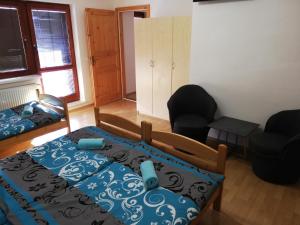 a bedroom with a bed and a chair and a bed and a couch at Guest House Zuzana in Habovka