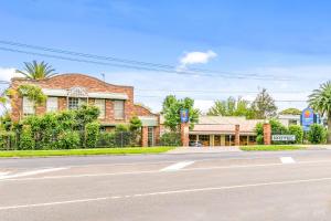 an empty street in front of a brick building at Comfort Inn Greensborough in Melbourne