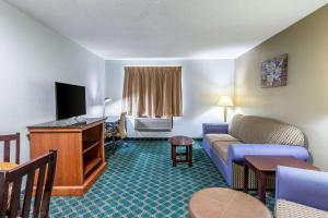 a hotel room with a couch and a tv at Econo Lodge Inn & Suites in Auburn