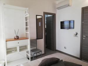 1 dormitorio con espejo, escritorio y silla en La Scogliera, en Avola