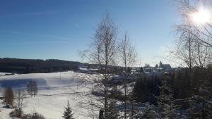 a snow covered field with the sun in the sky at Viehberghütte in Sandl