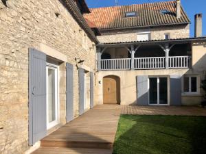a house with a wooden walkway in front of a building at Maison de caractère tout confort 8 pers proche grotte de Lascaux Périgord noir in Thenon