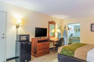 a bedroom with a television and a bed at Econo Lodge Inn & Suites Gulfport in Gulfport