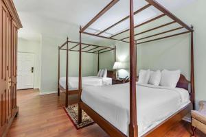 a bedroom with two beds with white sheets and wood floors at Admiral Fell Inn Baltimore Harbor, Ascend Hotel Collection in Baltimore