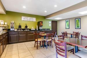 a restaurant with tables and chairs and a kitchen at Sleep Inn I-95 North Savannah in Port Wentworth