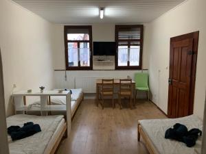 a room with two beds and a table and a dining room at Belle Vue Apartrooms in Fürth