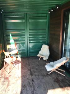 um quarto com duas cadeiras e uma porta verde em Estalagem Carucacas em Bom Jardim da Serra