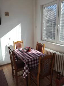 mesa de comedor y sillas con mantel a cuadros en Dora Apartment, en Kladovo