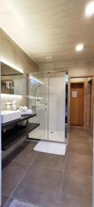 a bathroom with a glass shower and a sink at Hotel Cardiff in Ostend