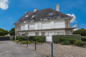 a large white house with a roof at Appartement vue mer in Bénodet