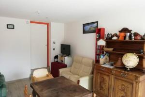 een woonkamer met een stoel en een tafel bij Appartement 2 pièces sur jardin en Pic Saint-Loup in Valflaunès
