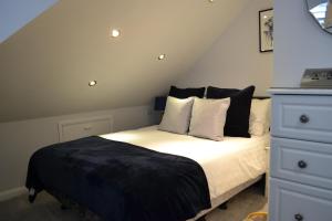 a bedroom with a bed with white sheets and pillows at Harriet House B&B in Canterbury