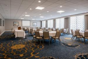 a conference room with tables and chairs and a screen at Holiday Inn South Kingstown-Newport Area, an IHG Hotel in South Kingstown