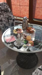 a glass table with a tray of food and drinks on it at Zimmervermietung Kolkwitz - Pension Geisler in Kolkwitz
