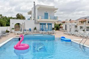 a swimming pool with a pink swan in the water at Kasapakis Hotel & Apartments in Hersonissos