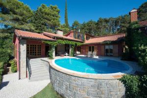 een huis met een zwembad in een tuin bij Vila Petra in Ankaran