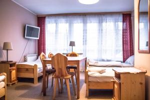 Pokój ze stołem i łóżkiem oraz sypialnią w obiekcie Willa Asta & Domek Pod Tatrami w Zakopanem
