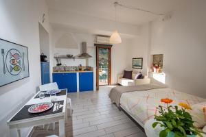 a bedroom with a bed and a table and a kitchen at Veranda sul Porticciolo in Castellammare del Golfo
