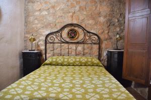 1 dormitorio con cama y pared de piedra en Casa Nasiet, en Camporrells